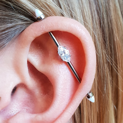 an industrial piercing in titanium with a marquise horizontal cz gem from Anatometal, either end is a white opal cone